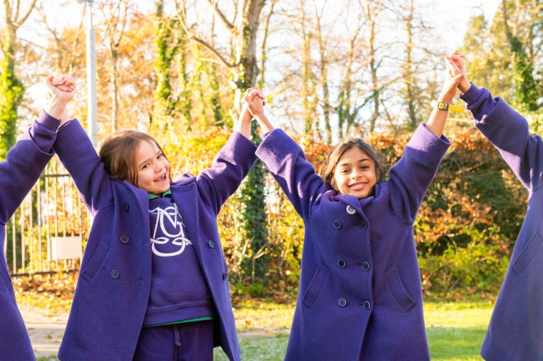 Pupils holding hands in the outdoor learning area at our all-girls private school in Buckinghamshire.