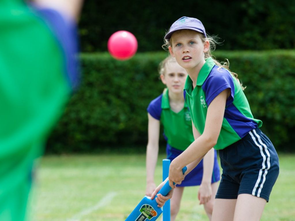 girl about to hit ball with cricket bat