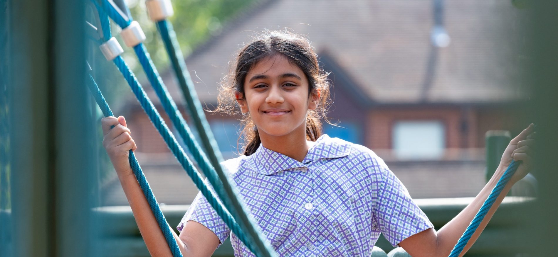 A school child on a climbing frame in the play park