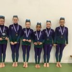 Happy students with their gymnastics medals and trophy