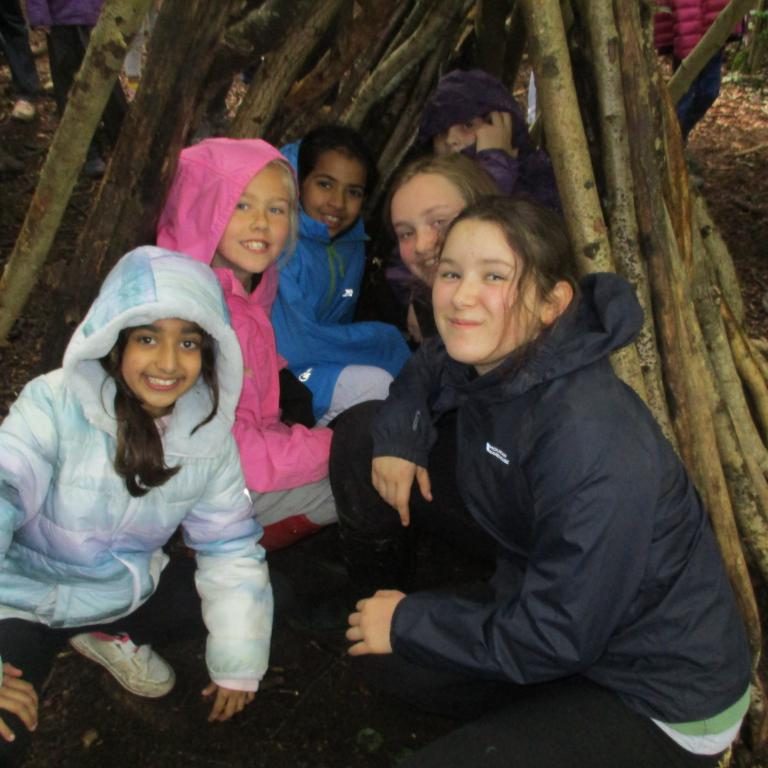 Students sat smiling in the wooden camp